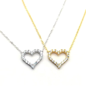 Close-up of gold and silver heart pendants with sparkling pavé cubic zirconia
