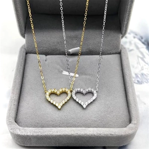 Close-up of gold and silver S925 heart pendants with micro-pave cubic zirconia