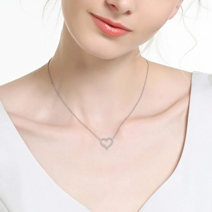 Close-up of S925 sterling silver heart pendant with shimmering diamonds on neck
