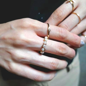 Detail of S925 silver pearl ring with five white shells and side diamond on finger