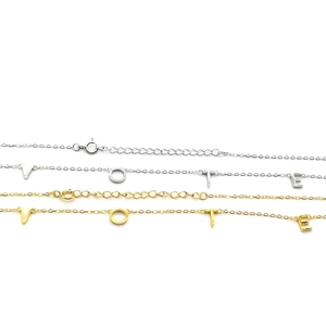 Detail of silver and gold VOTE letter pendant necklaces with adjustable extension chains