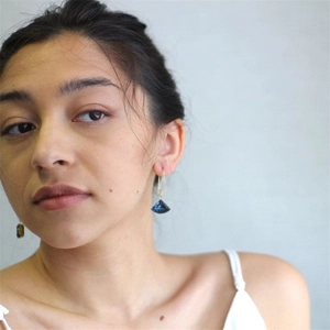 Détails des boucles d'oreilles éventail dorées avec des pierres bleues géométriques