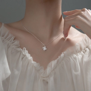 Close-up of S925 sterling silver four-leaf clover pendant necklace on a female neck