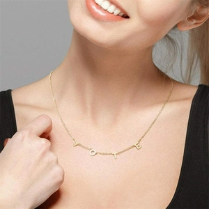 Close-up of a gold S925 sterling silver VOTE letter necklace on a female neck