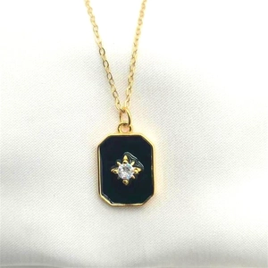 Detail of vintage gold octagonal pendant with black enamel and sparkling star center