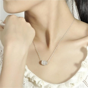 Close-up of S925 sterling silver necklace with cat-eye stone pendant on female model