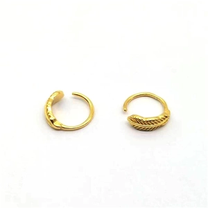 Macro detail of S925 silver golden feather hoop earrings with delicate engraved leaf patterns
