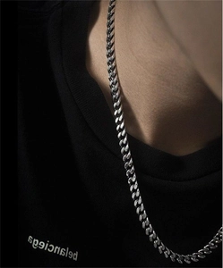 Close-up of S925 sterling silver Cuban link chain worn by a model on black t-shirt