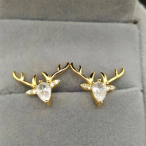 Macro detail of gold elk antler earrings with waterdrop zircon in a velvet jewelry box