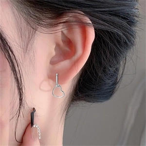 Close-up of S925 sterling silver heart hoop earrings worn on a female model's ear