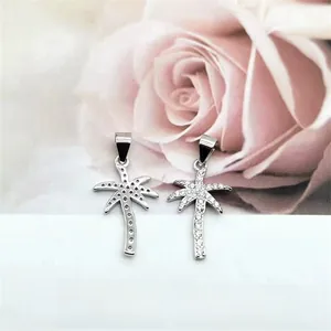Macro detail of S925 sterling silver palm tree pendants with sparkling pavé cubic zirconia