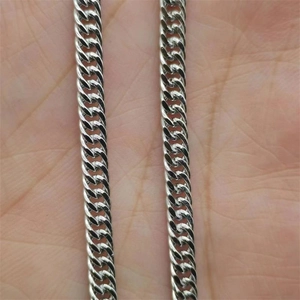 Macro shot of silver S925 sterling silver cuban link necklace on a person's palm