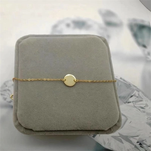 Minimalist S925 sterling silver round disc bracelet in gold on a jewelry box display