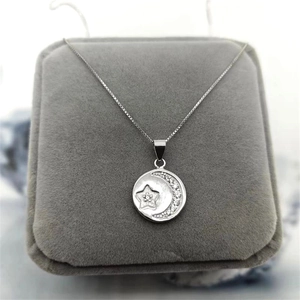 Detail of S925 sterling silver star and moon pendant with box chain in a jewelry box