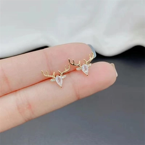 Macro view of gold reindeer stud earrings with crystal antlers and droplet zircon stones