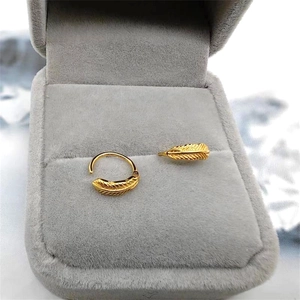 Elegant gold leaf hoop earrings in a gray jewelry box with detailed feather engraving
