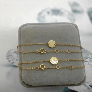 Detailed close-up of two polished S925 silver gold-plated disc charm bracelets on velvet