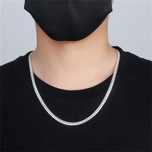 Close-up of a masculine S925 sterling silver curb chain necklace on a black shirt