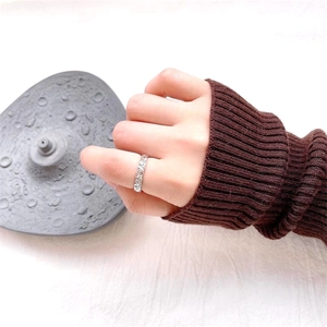 Detail of S925 sterling silver hammered ring with irregular texture worn with a sweater