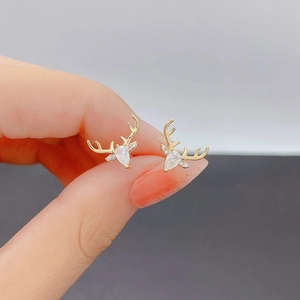 Close-up of gold reindeer stud earrings with pear-cut zircon and pave crystals