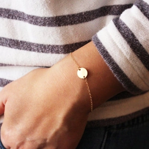 Minimalist S925 silver gold-plated bracelet with round disc pendant on woman's wrist