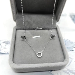 Gros plan du collier MOM en argent sterling 925 dans un coffret à bijoux en velours gris