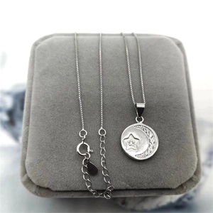 Detail of silver S925 star and moon pendant with crystals on grey velvet jewelry box
