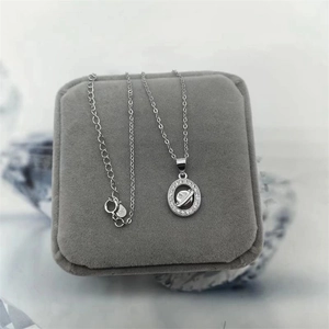 Detail of S925 sterling silver planet pendant with sparkling zircon in a gray jewelry box