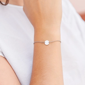 Detail view of a minimalist S925 sterling silver chain bracelet with a polished round charm