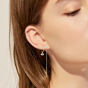 Detail of S925 gold-plated ear climber set with blue evil eye pendant and zircon tassel