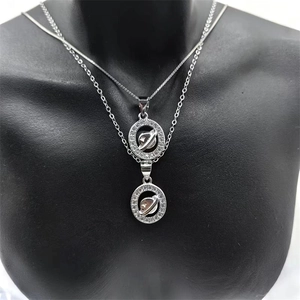 Close-up of double-layered silver Saturn planet pendant necklace on a model