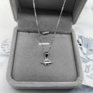 Pendentif dinosaure en argent S925 avec zircons scintillants sur un écrin de bijoux gris