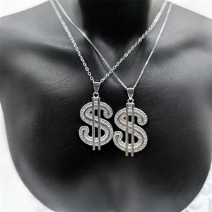 Macro-opname van dollarteken-hangers met kristallen op een zwarte buste-display