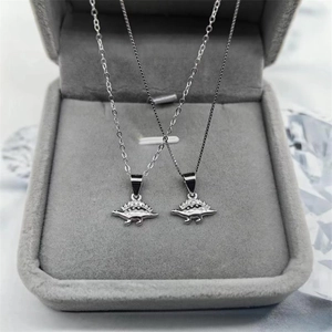 Élégants colliers avec pendentifs dinosaures en argent S925 et diamants dans un écrin gris