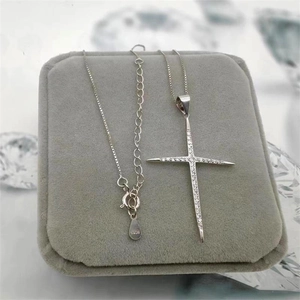 Gros plan du pendentif croix en argent sterling S925 avec cristaux sur écrin en velours