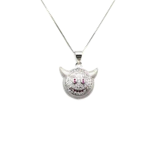 Macro shot of S925 silver devil pendant with white zircon pavé and red gemstone eyes