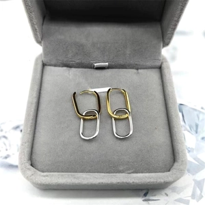 Close-up of S925 sterling silver oval interlocking hoop earrings in gold and silver finish