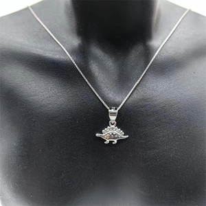 Détail du pendentif dinosaure en argent S925 avec petits diamants sur mannequin noir