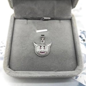 Macro shot of silver hip-hop devil pendant with paved white zircon and red eyes