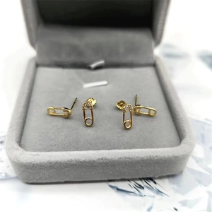 Détail de boucles d'oreilles trombone en argent doré avec cristaux dans un écrin gris
