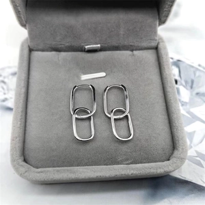 Macro detail of silver S925 oval double hoop earrings displayed in a grey velvet jewelry box