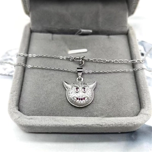 Macro shot of S925 silver devil face pendant with pink zircon eyes in a jewelry box