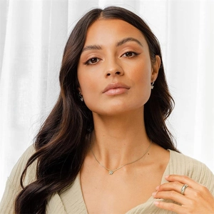 Detailweergave van vlinderhanger ketting, oorbellen en ringenset bij een model