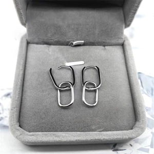 Close-up of S925 sterling silver oval interlocking earrings on grey velvet display