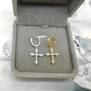 Macro shot of silver and gold S925 sterling silver cross earrings with zircon pavé