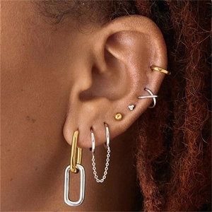 Close-up of stylish S925 silver and gold mixed earrings layered on a model's ear
