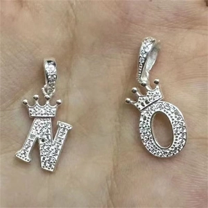 Détail des pendentifs couronne S925 argent lettres N et O avec texture dépolie
