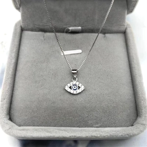 Gros plan du pendentif œil protecteur en argent S925 avec cristaux dans un écrin gris