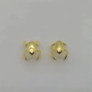 Detailed view of 1 pair of vivid golden frog-shaped sterling silver clip-on earrings