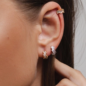 Close-up of S925 silver baguette-cut crystal ear cuff and hoop earrings on model ear